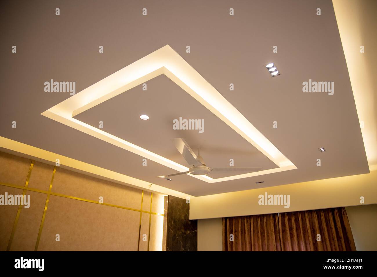 Ventilateur de plafond minimaliste dans le salon moderne peint dans des tons de peau et d'or Banque D'Images