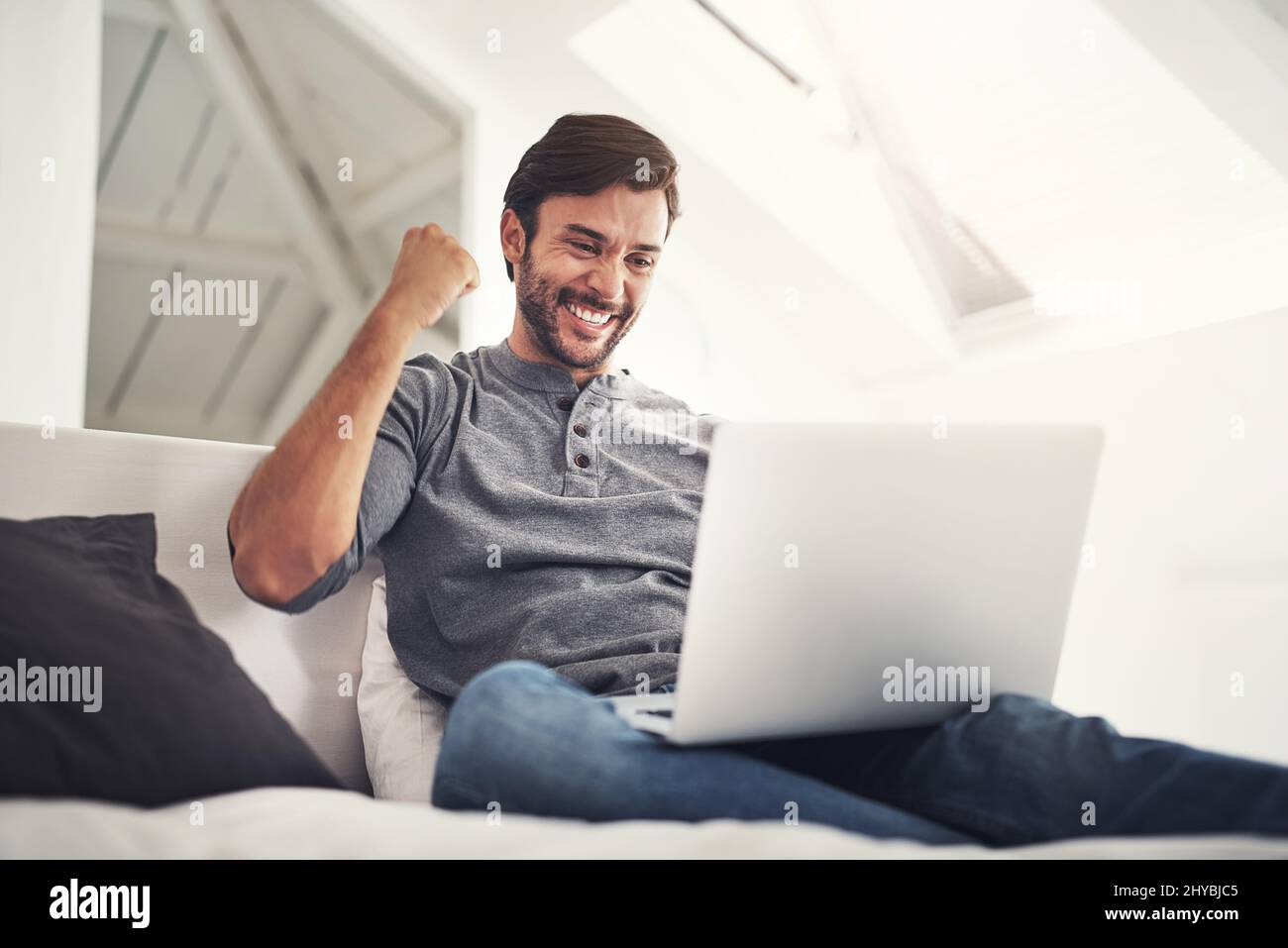 Oui, il a finalement été téléchargé. Photo d'un beau jeune homme surfant sur le net à la maison. Banque D'Images