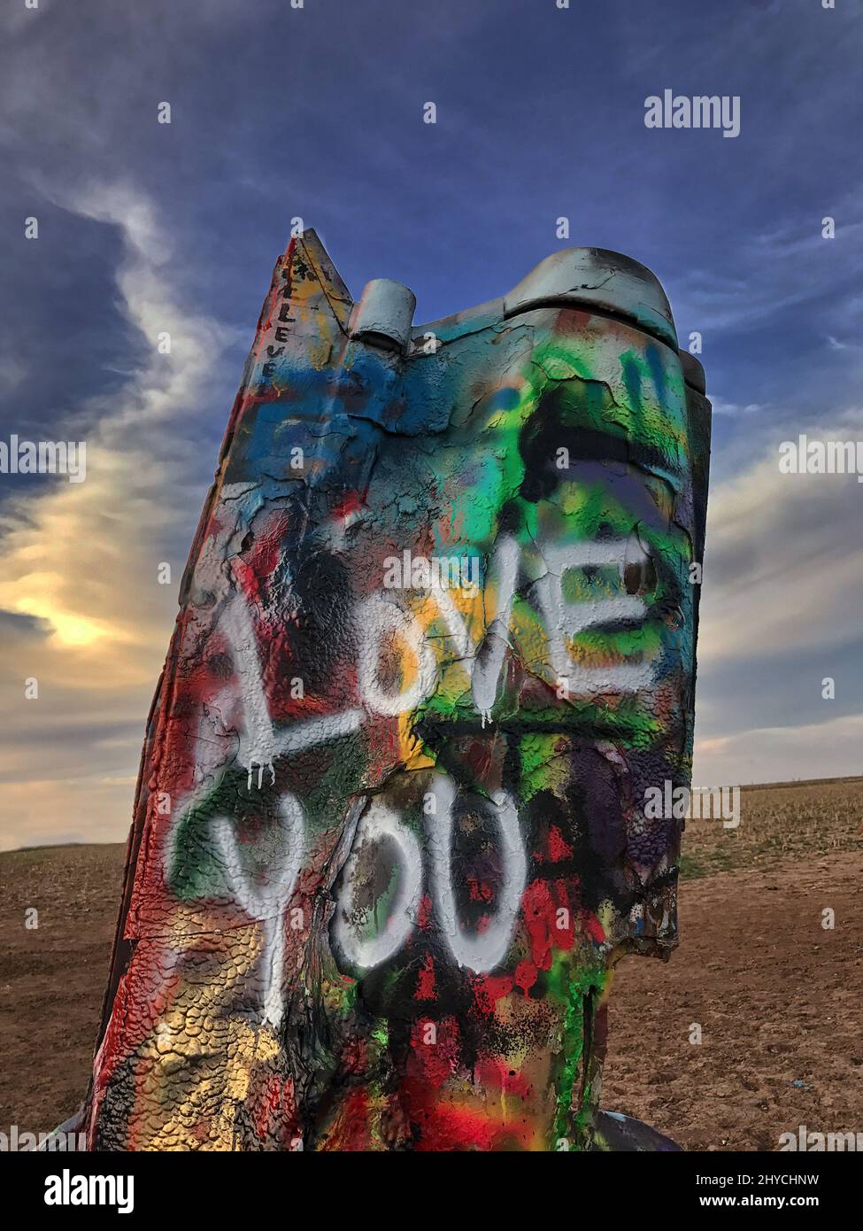 Cadillac Ranch n'est pas un ranch, mais une installation d'art public et de sculpture à Amarillo, Texas, États-Unis. Les automobiles Cadillac d'occasion sont à moitié enfouies le premier nez dans le sol, à un angle correspondant à celui de la Grande Pyramide de Gizeh en Égypte, et montrent les différents styles de nageoires de queue. Cadillac Ranch est visible depuis l'autoroute, à la sortie de la route 66. Situé sur un terrain privé, la visite est encouragée. En outre, l'écriture de graffiti sur les véhicules ou la peinture par pulvérisation est maintenant encouragée. Chaque fois que vous visitez, c'est une expérience différente, car elle change toujours Banque D'Images