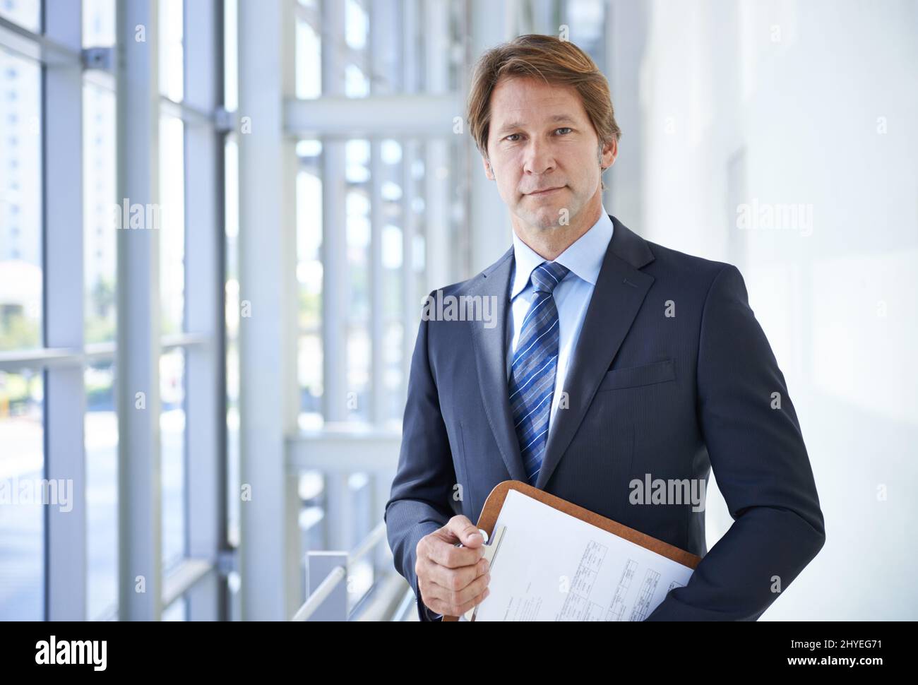 Les planchettes Sont un élément essentiel de l'entreprise. Photo d'un homme d'affaires mûr tenant une planchette à pince dans un immeuble de bureaux. Banque D'Images