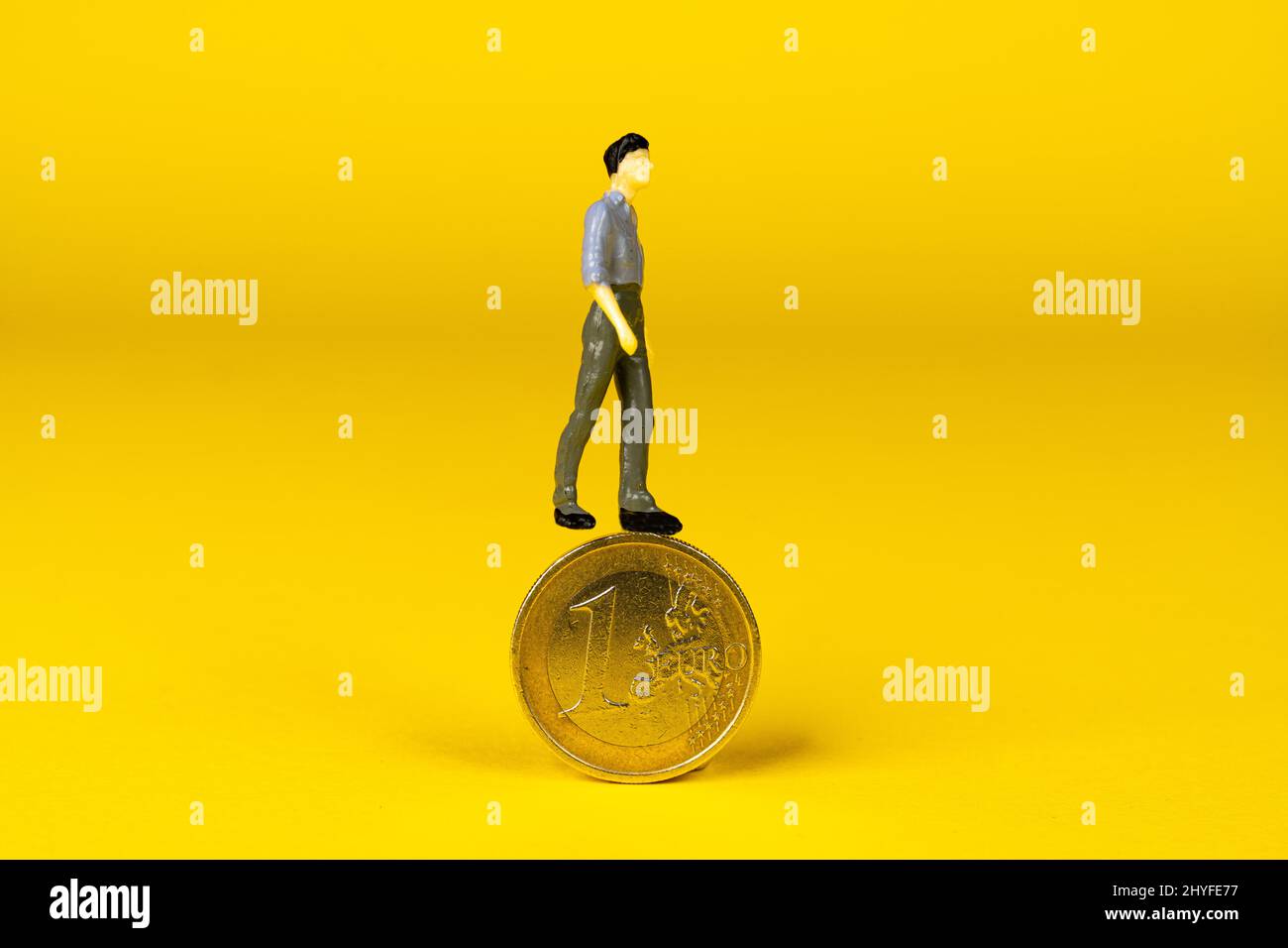 un mannequin survolant une pièce de 1 euros Banque D'Images