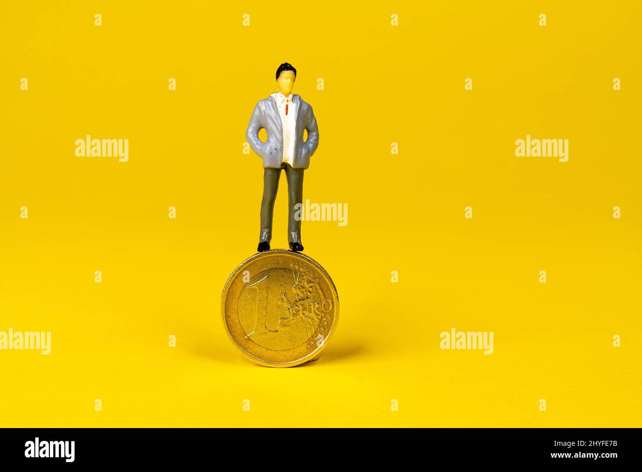 un mannequin survolant une pièce de 1 euros Banque D'Images