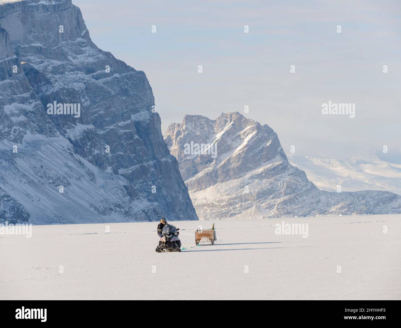 Motoneige d'un Inuit sur la glace de mer d'un fjord gelé près de Saatut. Uummannaq pendant l'hiver dans le nord de la Westgreland, au-delà du cercle arctique. Non Banque D'Images