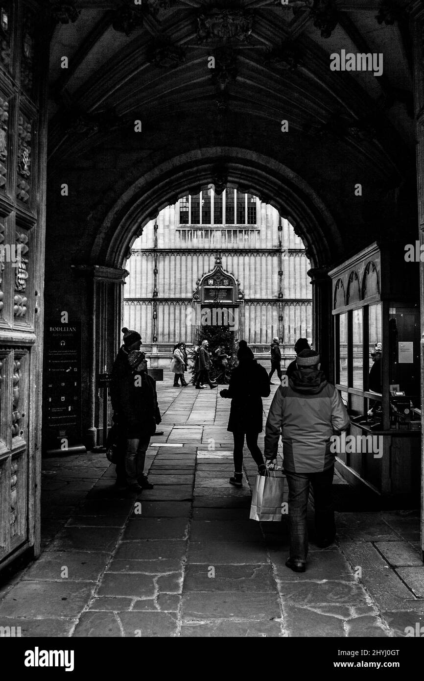 Prise de vue en niveaux de gris de personnes marchant sur le campus de l'université d'Oxford Banque D'Images