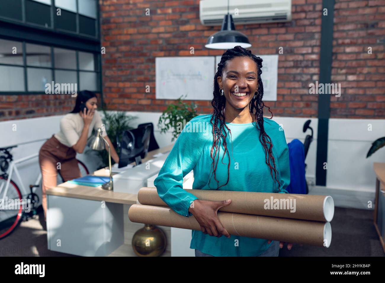 Portrait de jeunes architectes afro-américains souriants debout avec des tubes en carton Banque D'Images