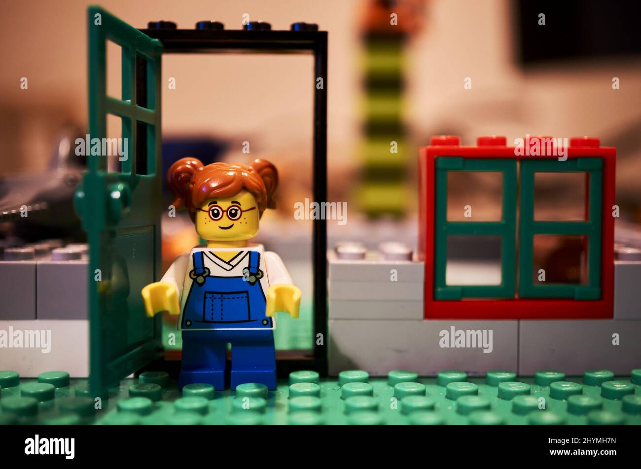 Gros plan d'une petite fille jouet Lego avec des lunettes debout près d'une  porte ouverte Photo Stock - Alamy