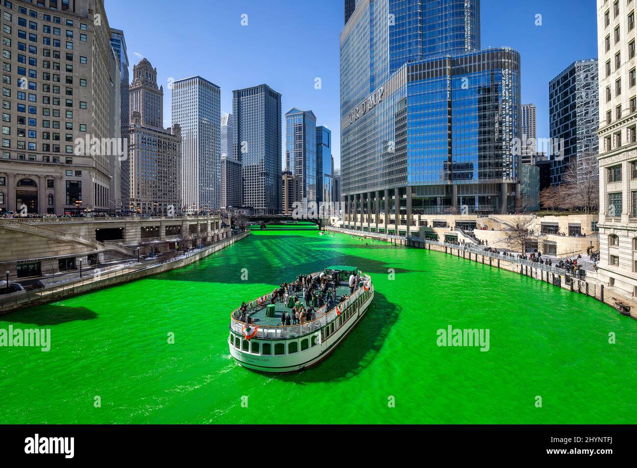 Plusieurs bateaux et kayaks naviguent le long de la rivière Chicago qui a été teints vert pour célébrer la Saint Patrick's Day dans le centre-ville de Chicago. Banque D'Images