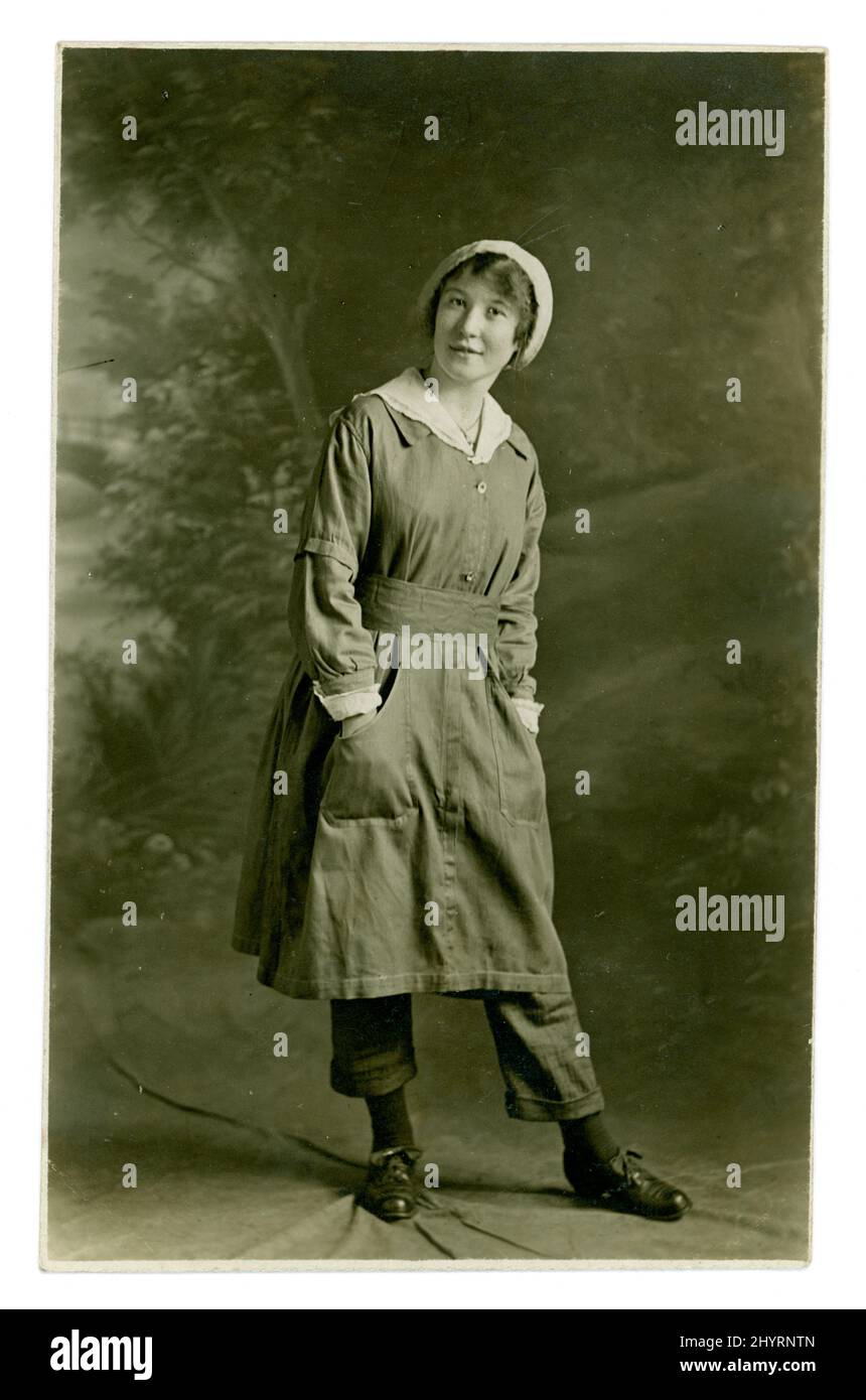 Carte postale de l'ère WW1 d'une travailleuse de munitions montrant fièrement son uniforme, qui comprend un pantalon, peut-être Yorkshire, Royaume-Uni vers 1917 Banque D'Images