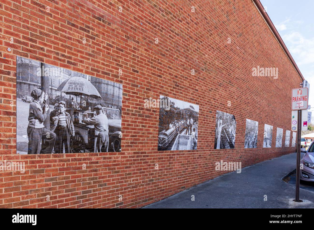 BELMONT, NC, USA-8 MARS 2022: Mur de briques recouvert de multiples grands tirages noir et blanc de scènes du milieu du XXe siècle. Banque D'Images