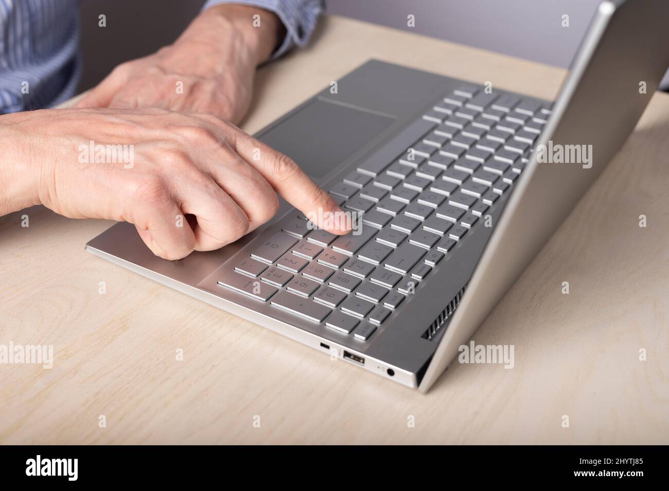 Homme main fermer à l'aide de l'ordinateur portable et en appuyant sur la touche entrée. Saisie de messages, recherche d'informations, réalisation de projets, utilisation de l'ordinateur pour le travail et le concept d'éducation. Photo de haute qualité Banque D'Images