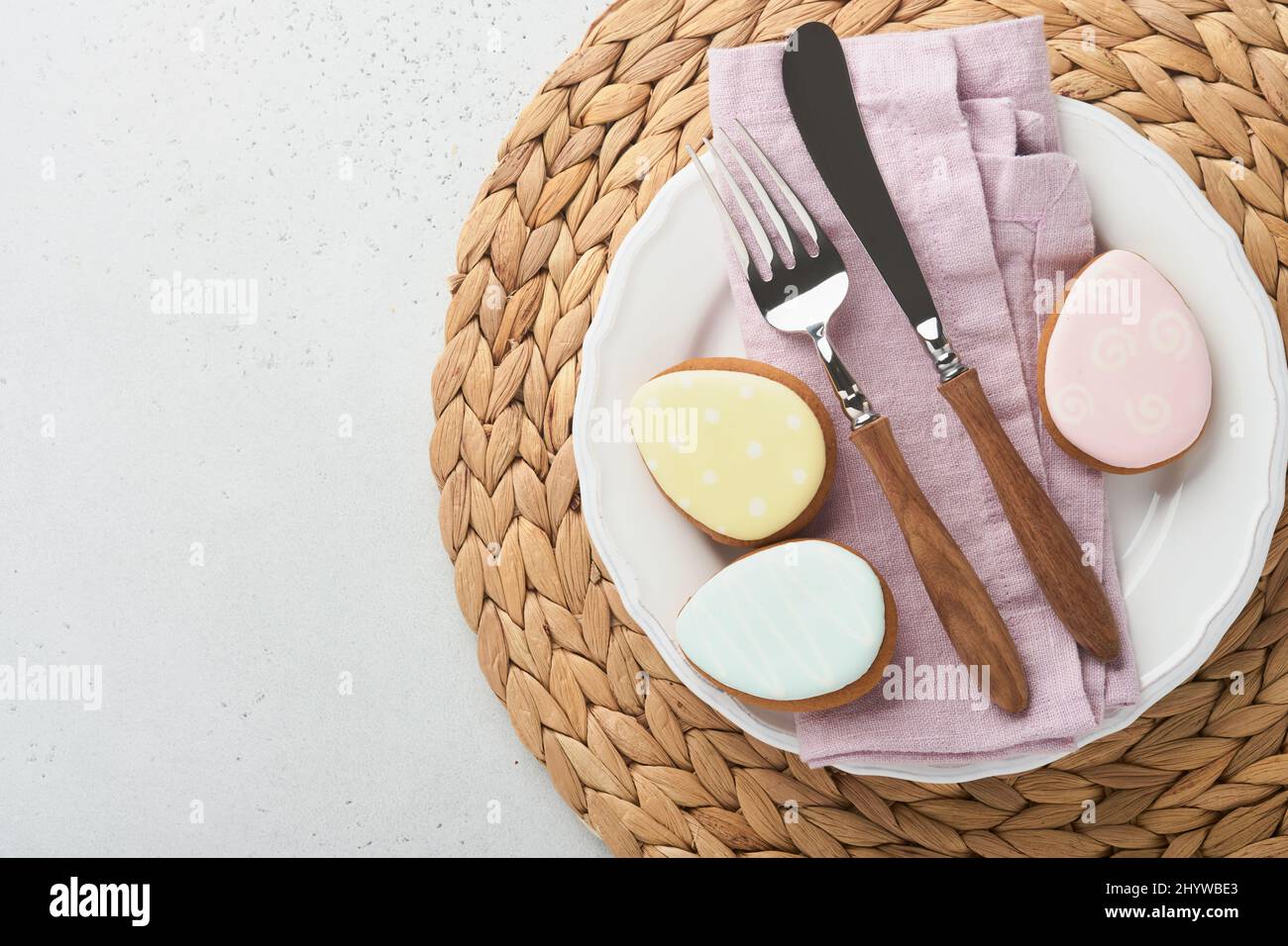 Réglage de la table de Pâques. Dîner de Pâques avec œufs de pâques multicolores. Les nappes pastel et roses sont élégantes. Vue de dessus. Tradition religieuse chrétienne Banque D'Images