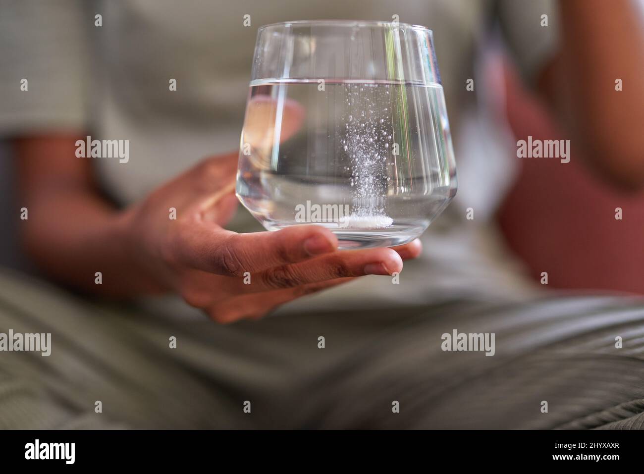 Un gros plan d'un comprimé effervescent fuzzy dans un verre d'eau pour le traitement de la grippe Banque D'Images