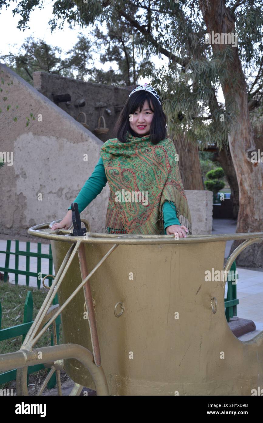 Photo verticale d'une chinoise dans une ancienne calèche dorée au Caire, en Égypte Banque D'Images