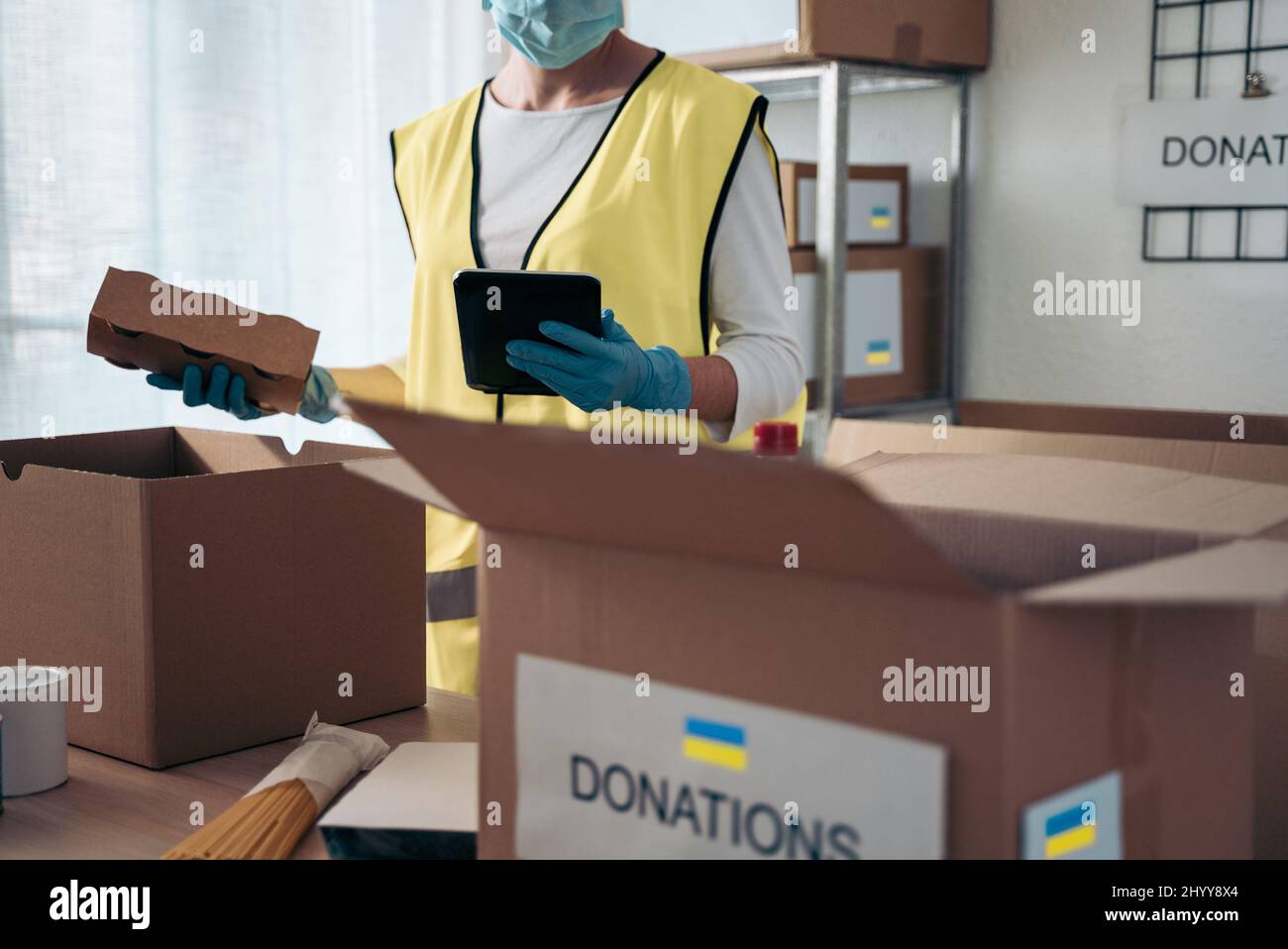 Bénévoles collectant des dons pour les réfugiés d'Ukraine pendant la guerre avec la Russie - aide caritative pendant l'épidémie de coronavirus - Focus sur l'ordinateur tablette Banque D'Images