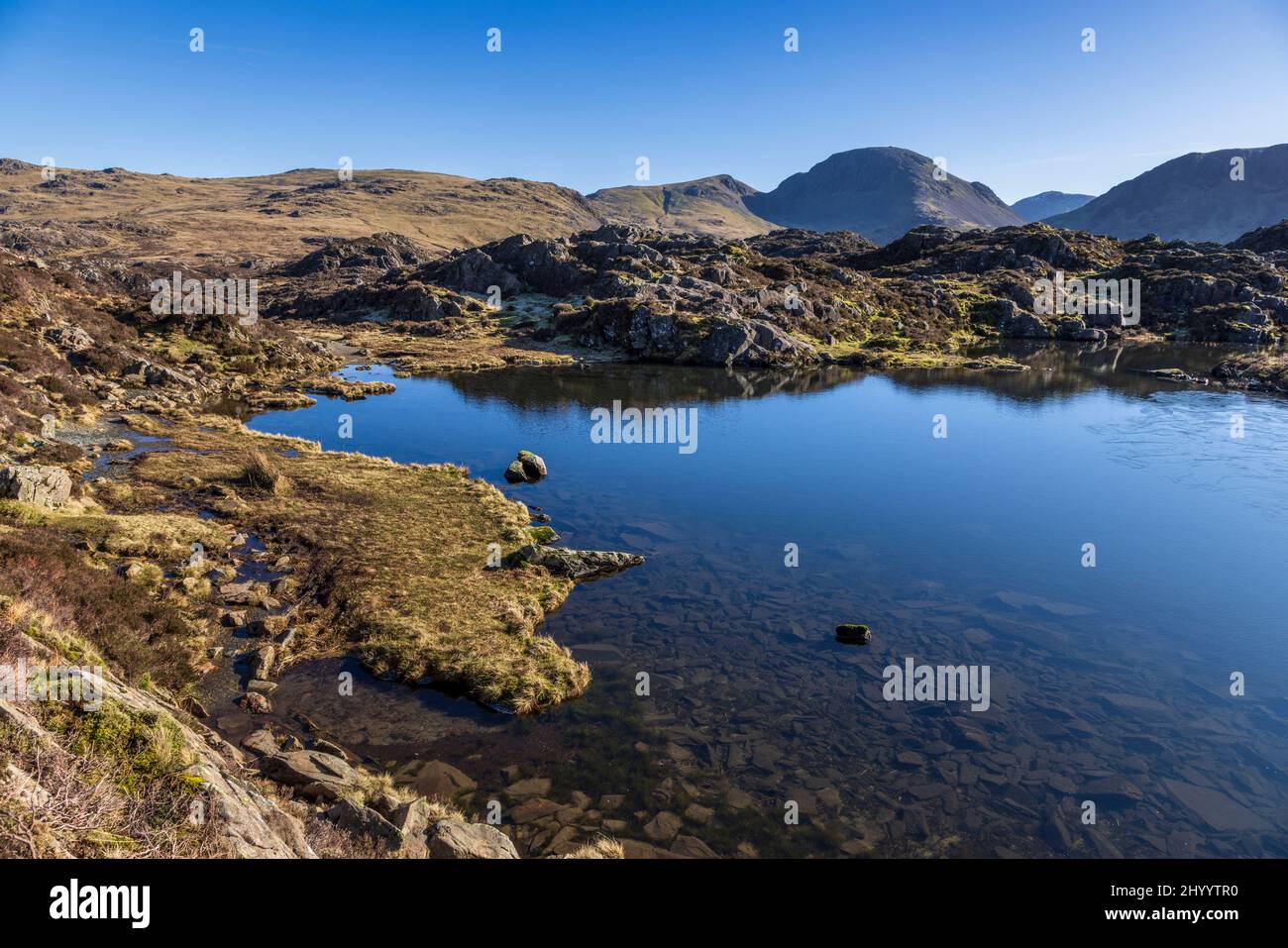 L'innominate Tarn sur les piles de foin tomba dans les coquillages de Buttermere, Lake District, Angleterre Banque D'Images
