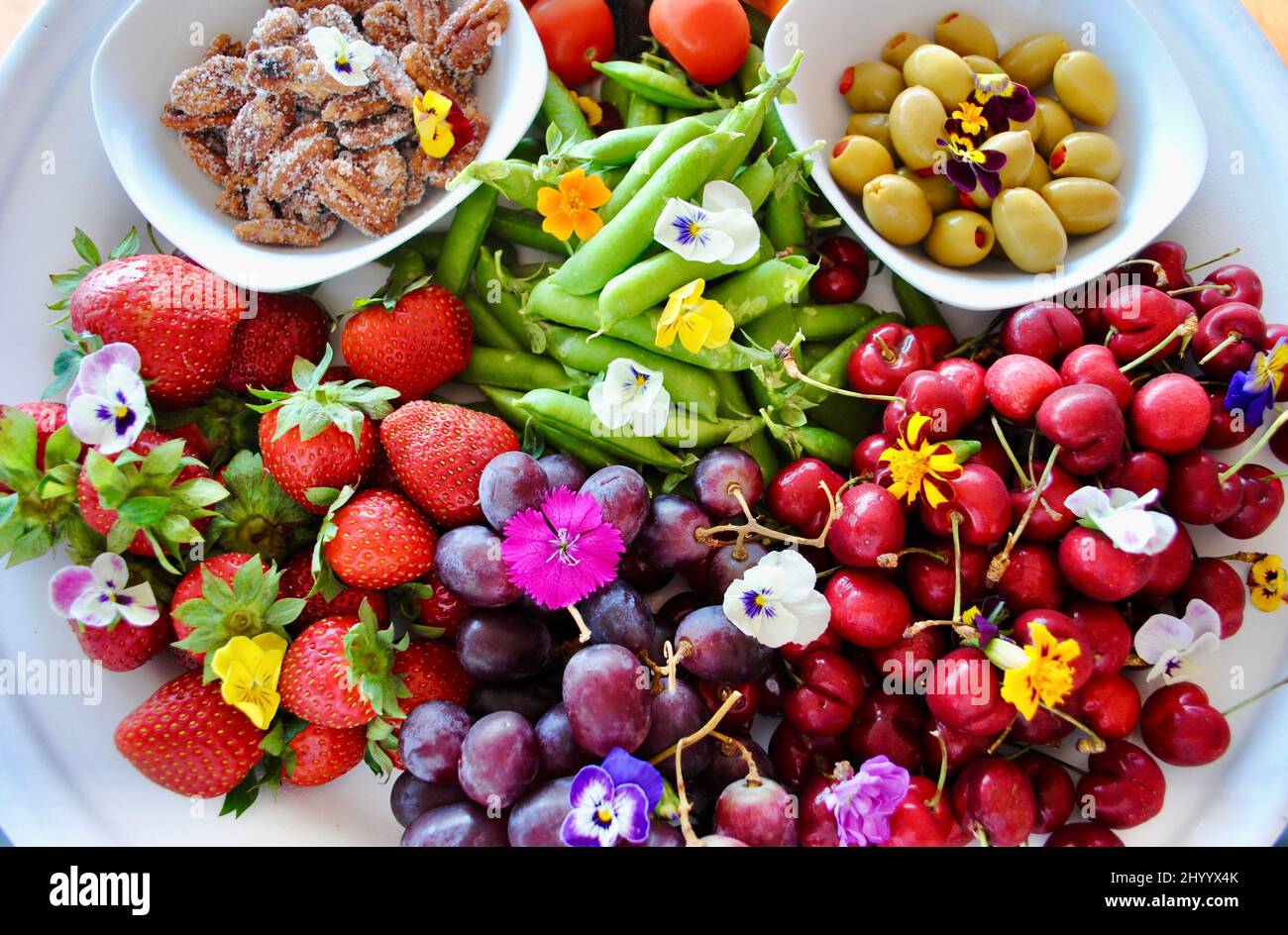 Crudités, noix et olives décorées de fleurs comestibles Banque D'Images