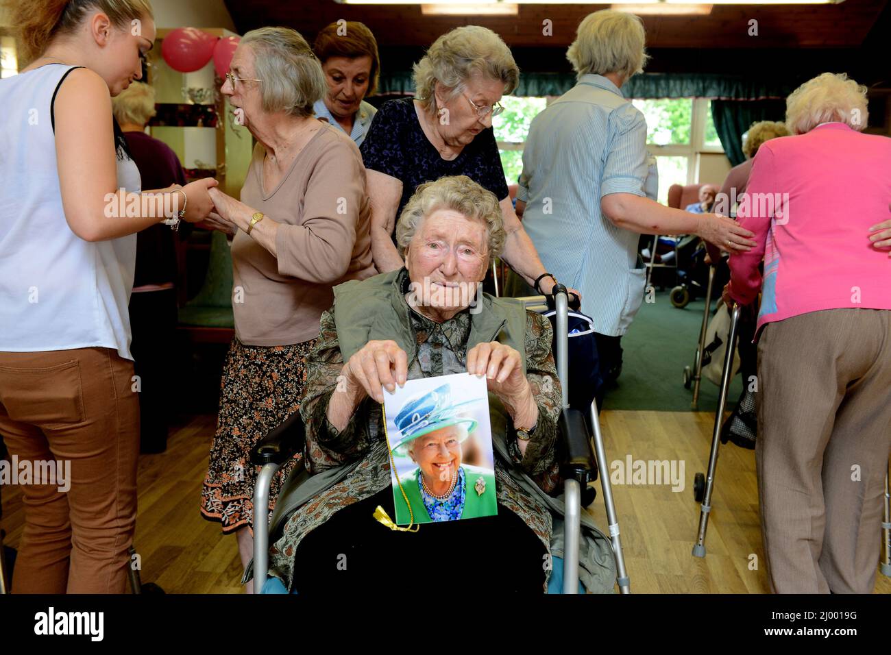 La résidente de Care Home célèbre son anniversaire de 100th tout en tenant sa carte de la Reine. Banque D'Images
