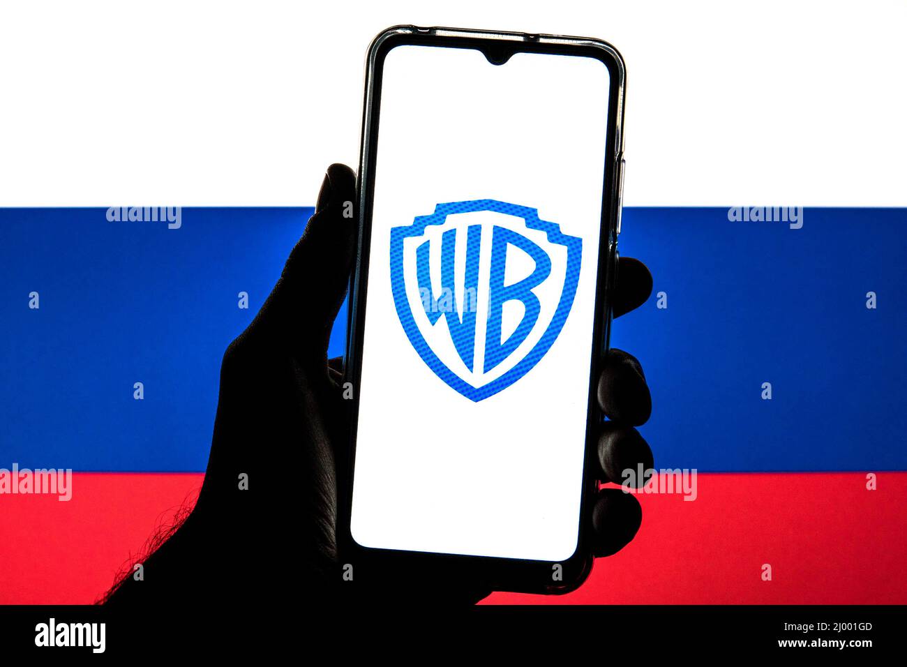 Sur cette photo, un logo Warner Bros est affiché sur un smartphone avec un drapeau de la Russie en arrière-plan. Banque D'Images