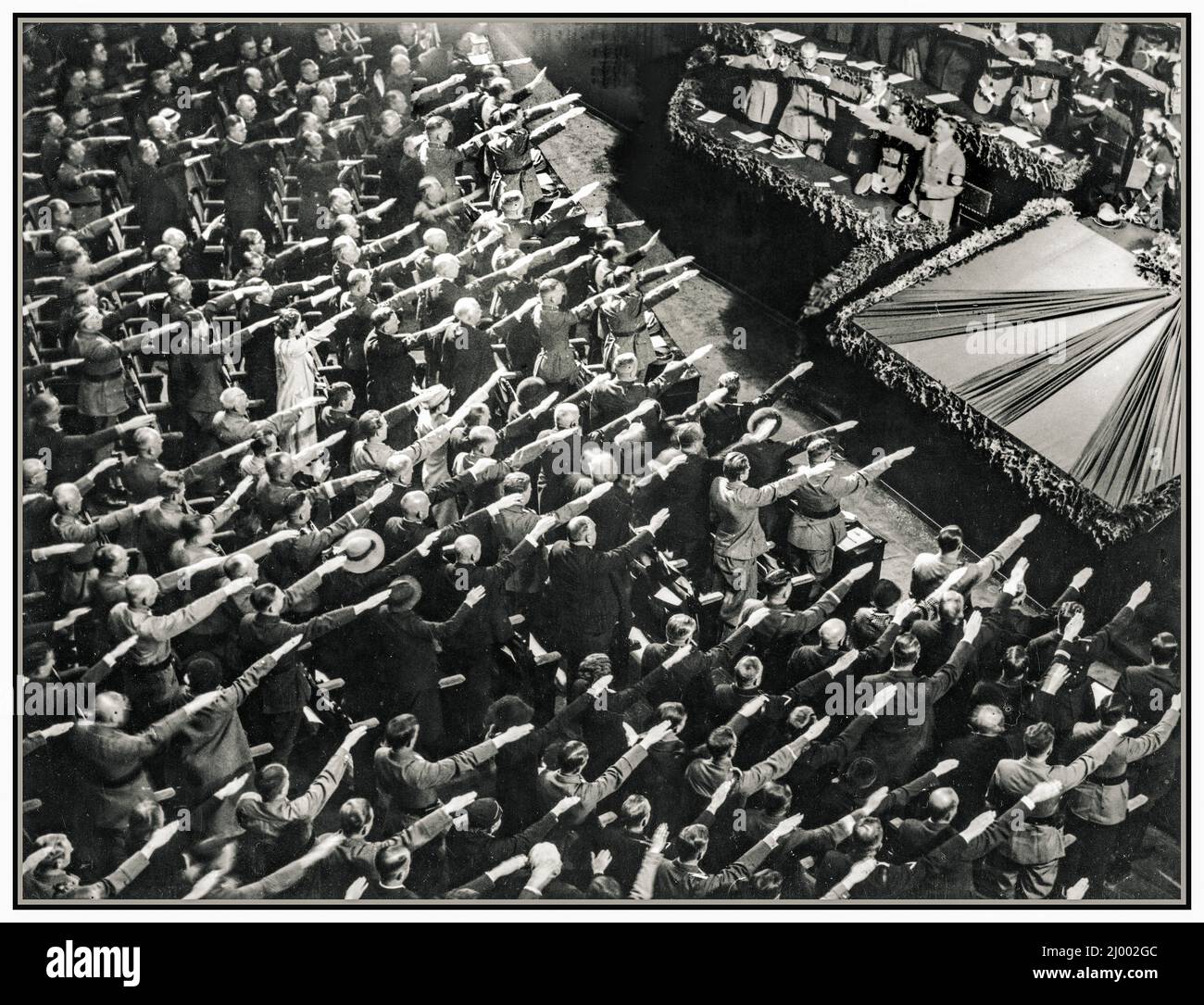 WINTERHILSWERK Allemagne nazie HEIL HITLER SALUE LA FOULE 1935 dans l'Opéra de Kroll à Berlin, le début des travaux pour l'aide d'hiver a été fessely ouvert par Fuhrer Adolf Hitler. Les personnes présentes apportent le salut nazi de Heil Hitler et chantent l'hymne national. Dans ce bâtiment, Hitler a annoncé le déclenchement de la Seconde Guerre mondiale en 1939. Banque D'Images