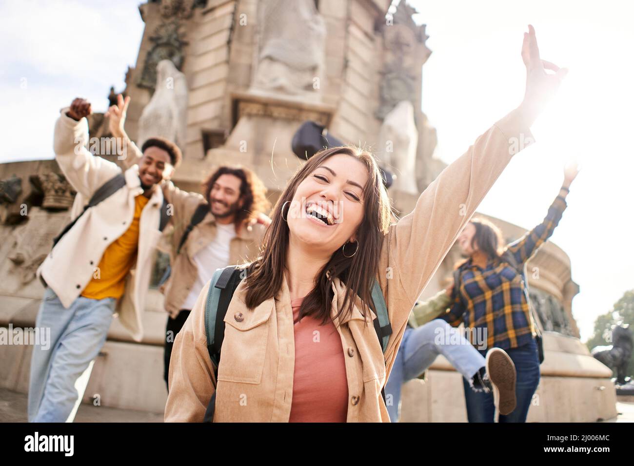 Groupe de jeunes étudiants de l'université célébrant le succès. Jeunes amis joyeux regardant l'appareil photo avec les bras vers le haut Banque D'Images