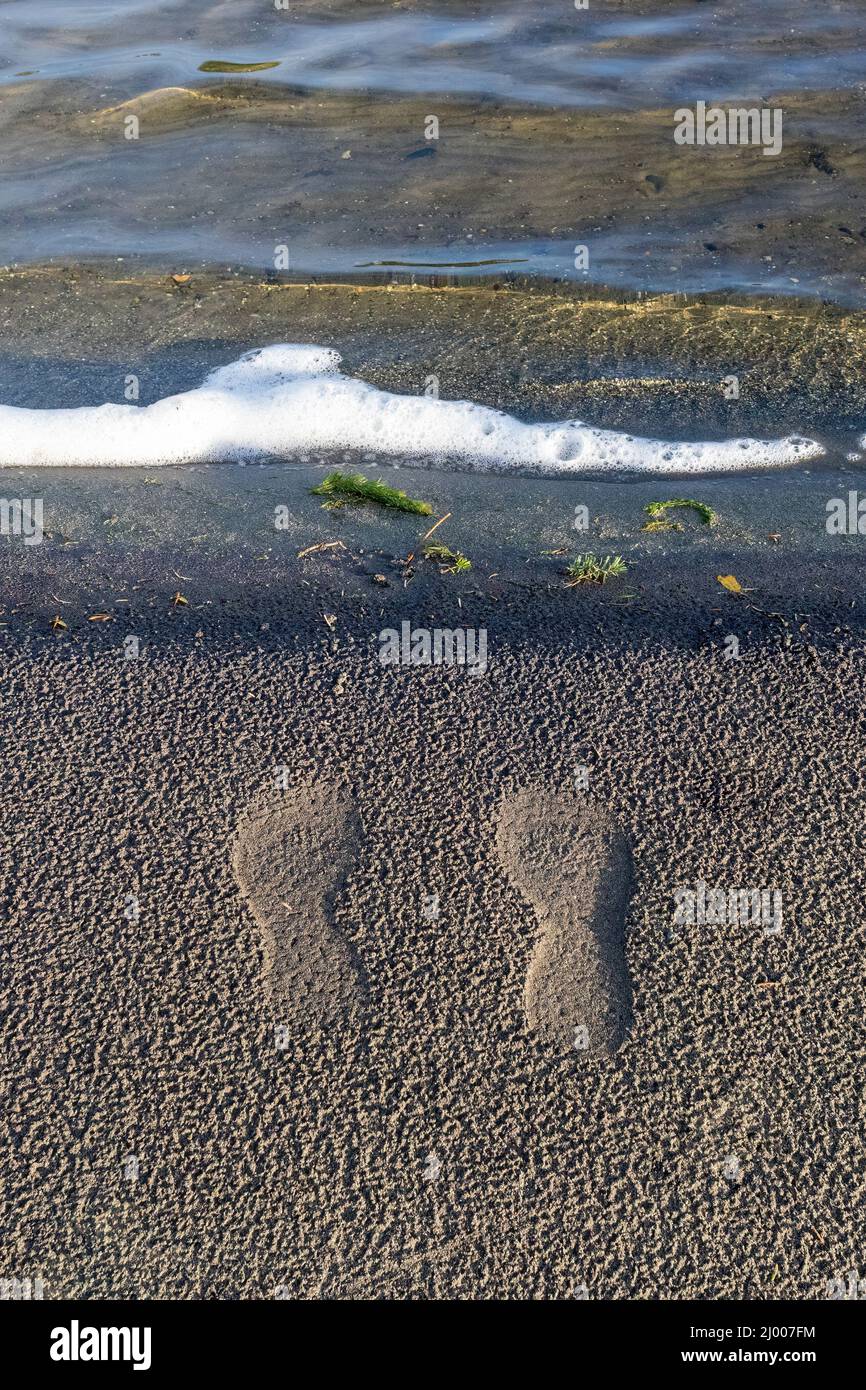 empreintes de pas dans le sable près du rivage surf Banque D'Images