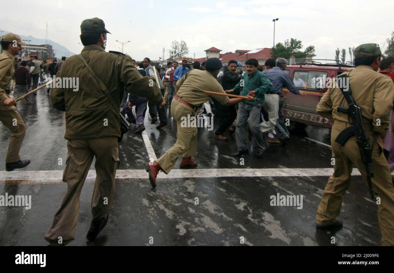 Des policiers qui battent des employés du gouvernement de l'État de Jammu-et-Cachemire protestent devant le secrétariat civil à Srinagar. La police a utilisé des canons à eau et des gaz lacrymogènes pour disperser des centaines d'employés du gouvernement exigeant une régularisation de leurs emplois et une augmentation de leur salaire. Cachemire, Inde. 5 mai 2008. Banque D'Images