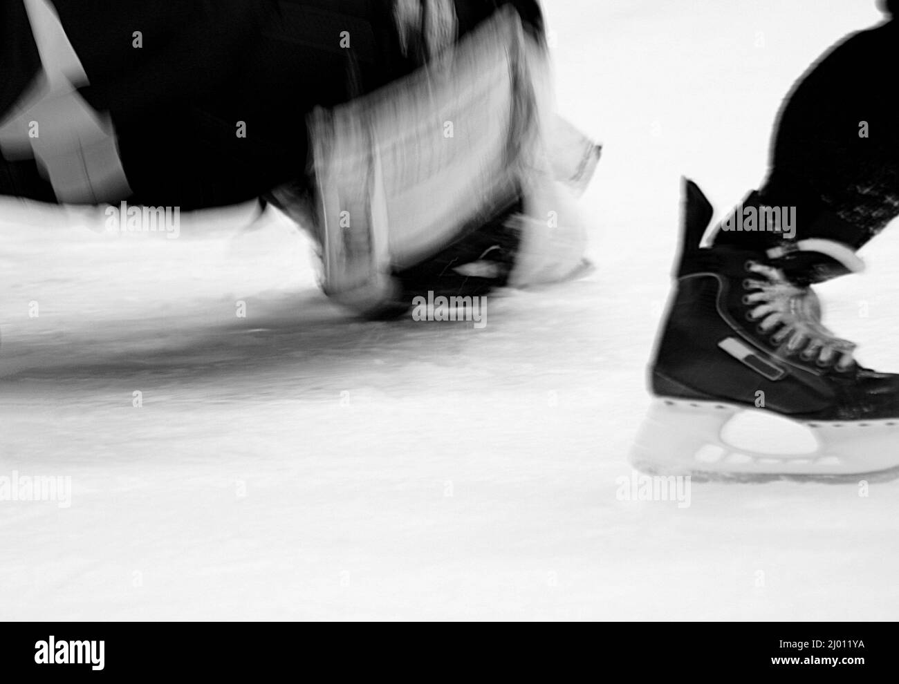 Gros plan sur le gardien de but et le pied du patineur en mouvement pendant l'entraînement de hockey Banque D'Images