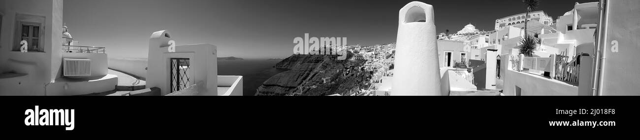 Vue panoramique sur le village de Fira Santorini et la mer égée lors d'une belle journée ensoleillée en noir et blanc Banque D'Images