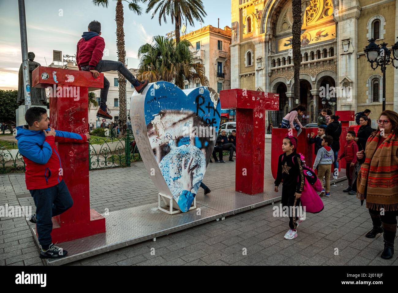 Les enfants grimpent et jouent sur le panneau « J'aime Tunis » en face de la cathédrale Saint-Vincent-de-Paul, Tunis, Tunisie Banque D'Images