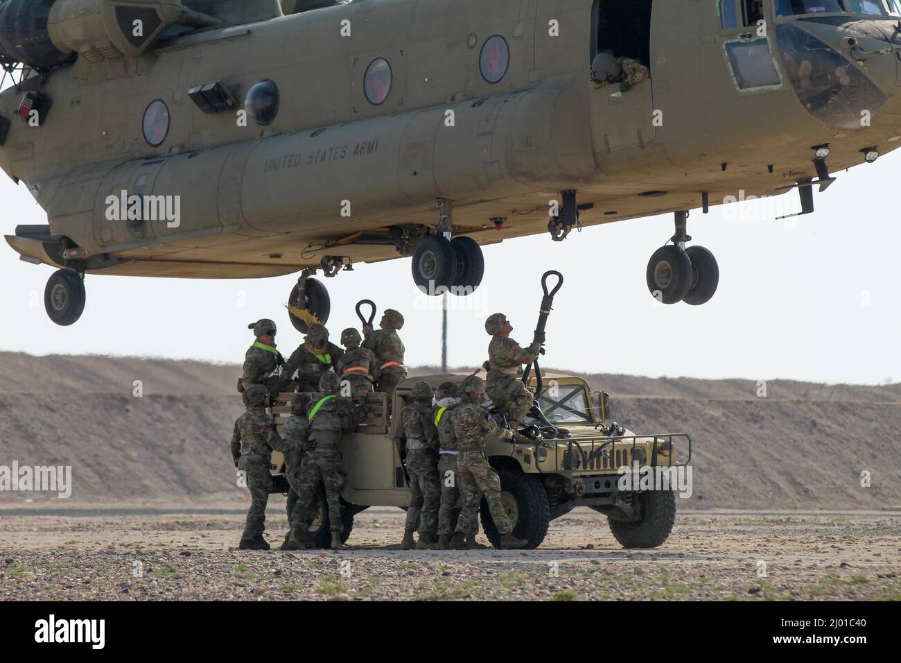 Soldats de l'armée américaine avec la Compagnie de camion composite 1067th, le 228th Bataillon de transport automobile, le 213th Regional support Group, la Garde nationale de l'armée de Pennsylvanie, le 389th Bataillon de soutien au combat, la 77th Brigade de soutien, Et un soldat britannique affecté à la Brigade aérienne de combat de 16 attache un Humvee à un CH-47 Chinook lors d'un exercice d'entraînement au Camp Buehring, au Koweït, le 26 février 2022. Les soldats s'étaient formés dans le cadre de la Force opérationnelle interarmées combinée – opération détermination inhérente de conseiller, d'aider et de permettre aux forces en partenariat de vaincre durablement Dae Banque D'Images