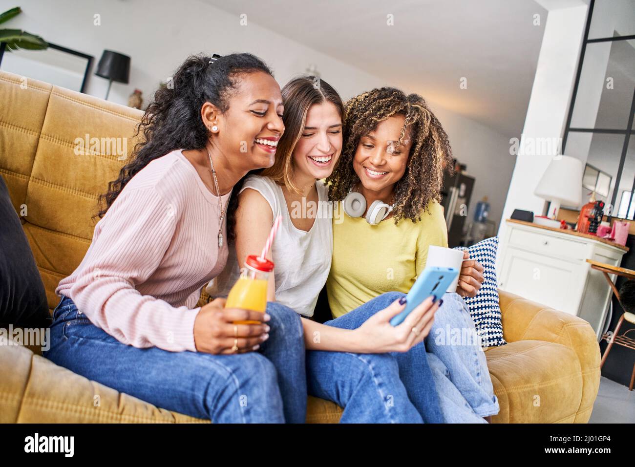 Trois femmes souriantes et souriantes qui utilisent un téléphone intelligent mobile avec écran numérique. Shopping en ligne réseau social personnes dépendantes Banque D'Images