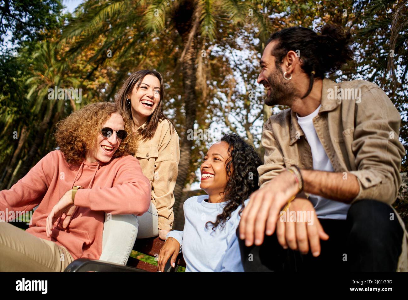 Des gens heureux et joyeux rient dans le parc avec des amis multiraciaux Banque D'Images