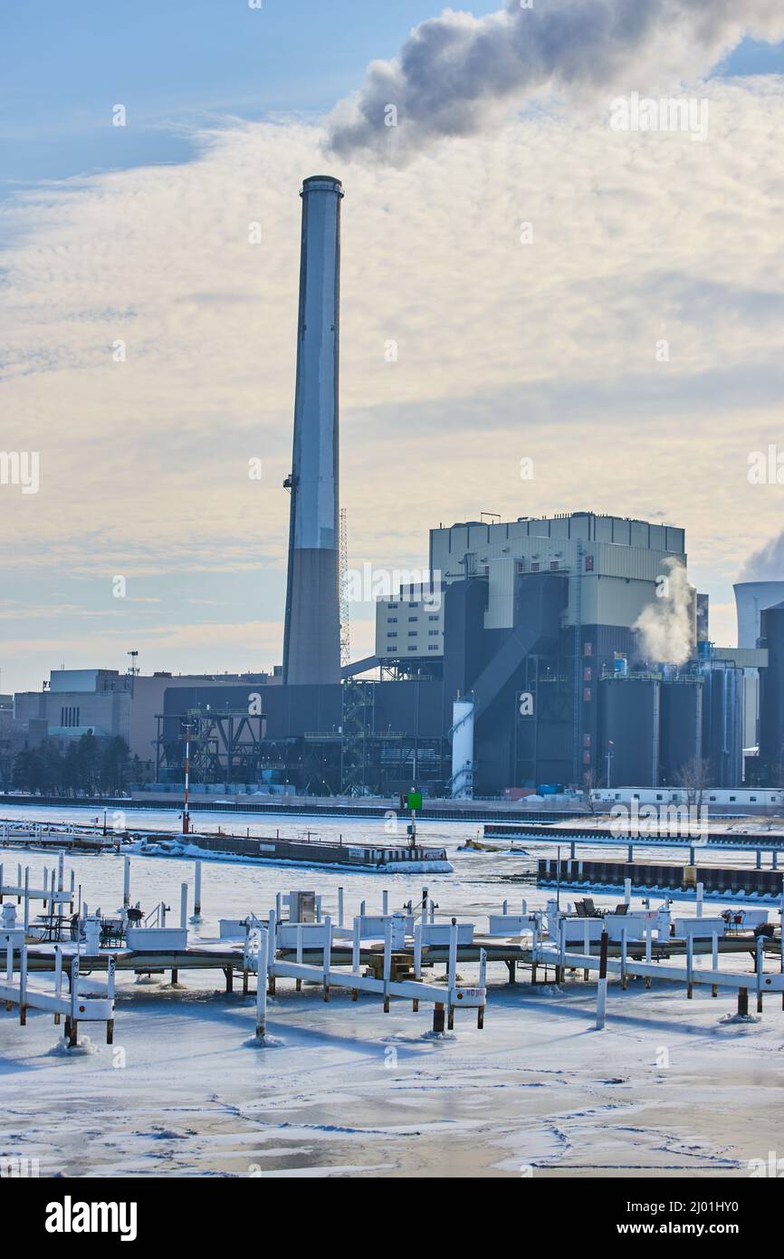 Quais sur le lac avec grande usine en arrière-plan Banque D'Images
