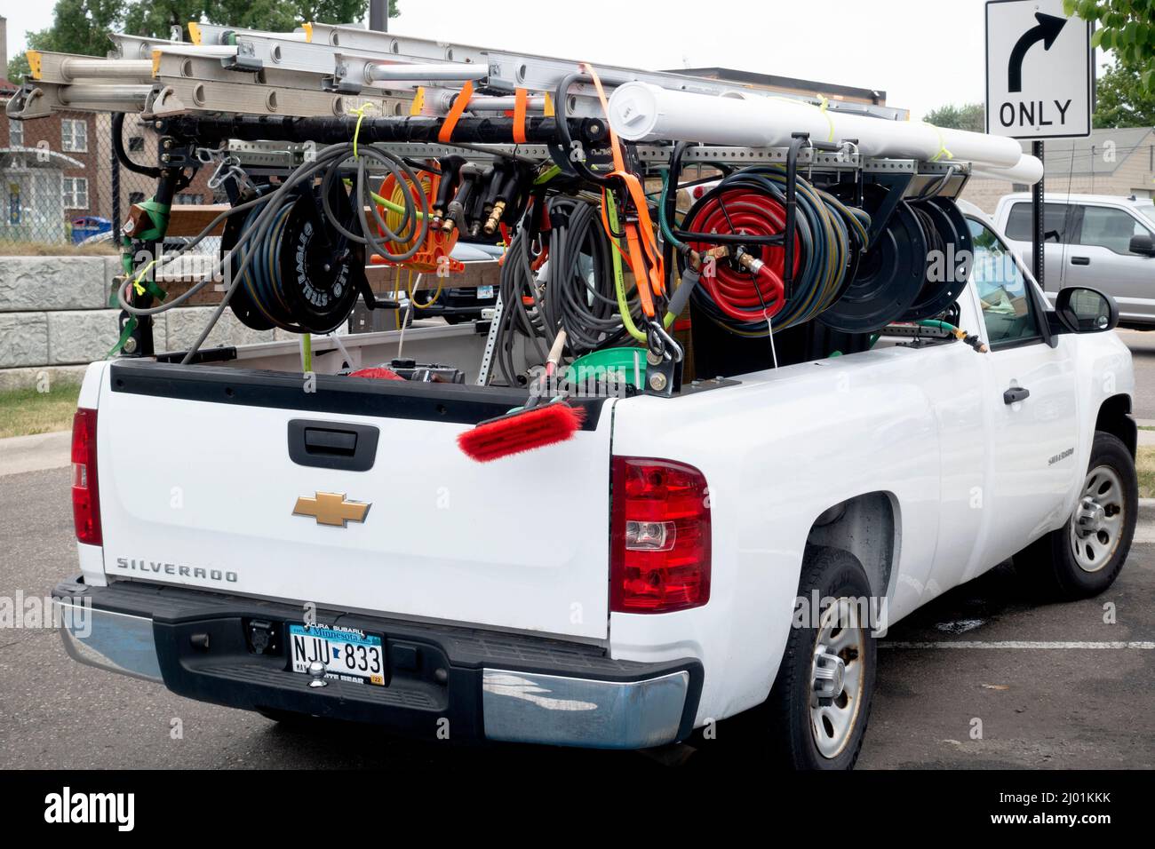 Paquet de camions utilitaires blanc rempli de flexibles et de fils avec une échelle sur le dessus. Minneapolis Minnesota MN États-Unis Banque D'Images