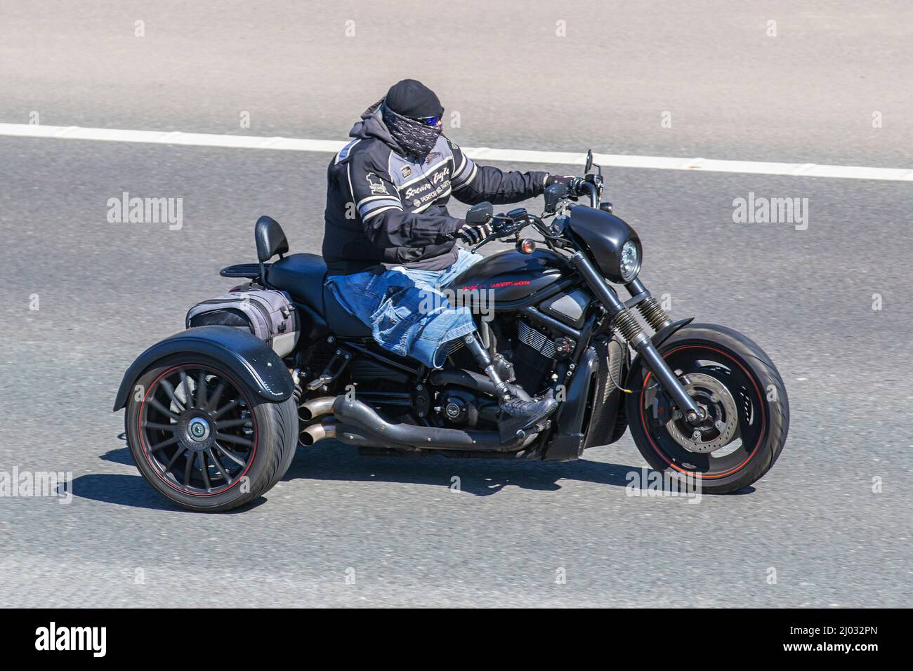 Motocycliste handicapé portant une prothèse un remplaçant artificiel pour un membre manquant profite d'une promenade sur son Harley-Davidson Trike dans des conditions de soleil sur l'autoroute M6. Banque D'Images