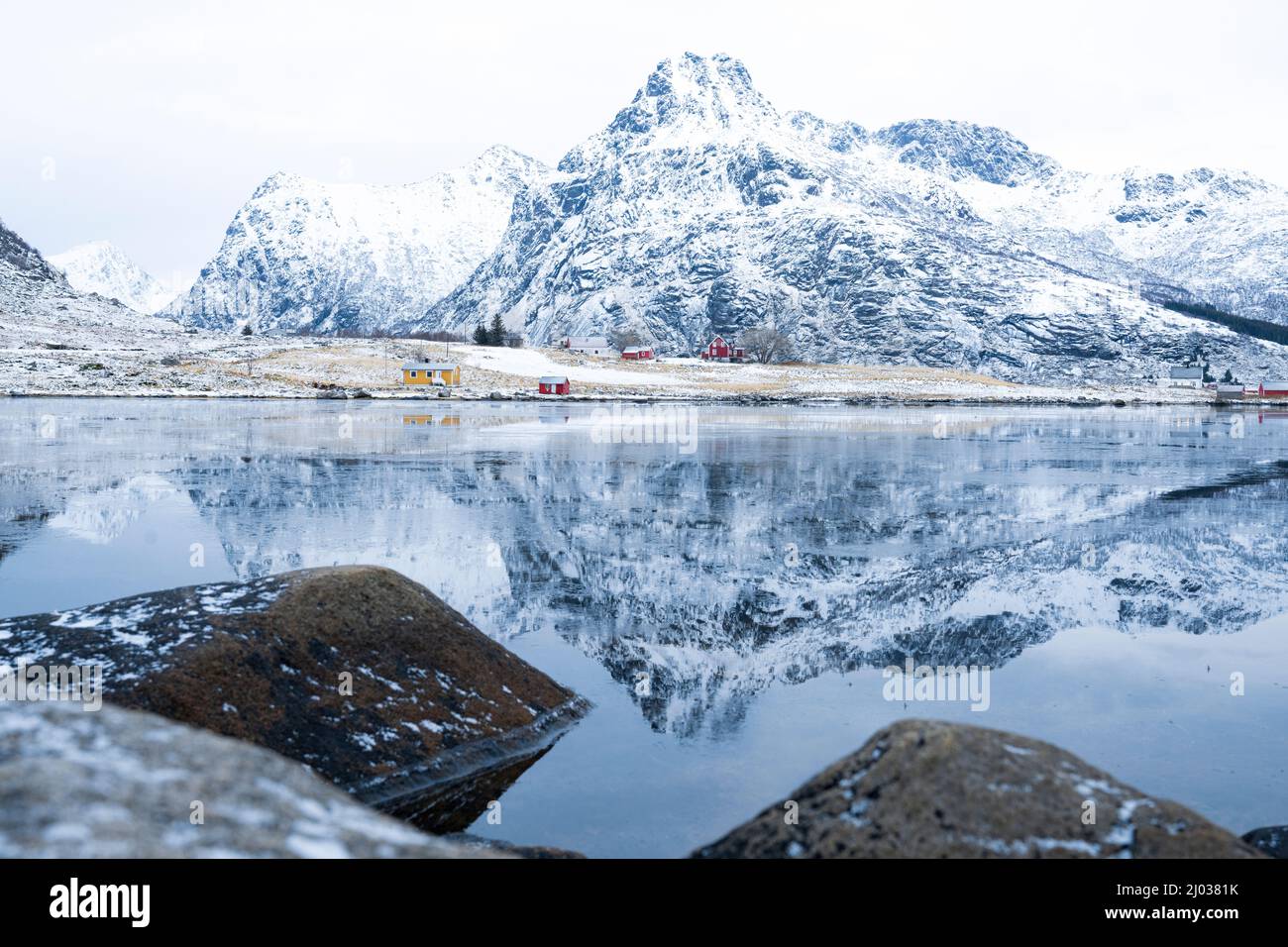 Majestueux sommets de montagne reflétés dans la mer glacée en hiver, Flakstadpollen, Flakstadoya, Nordland, îles Lofoten, Norvège, Scandinavie, Europe Banque D'Images