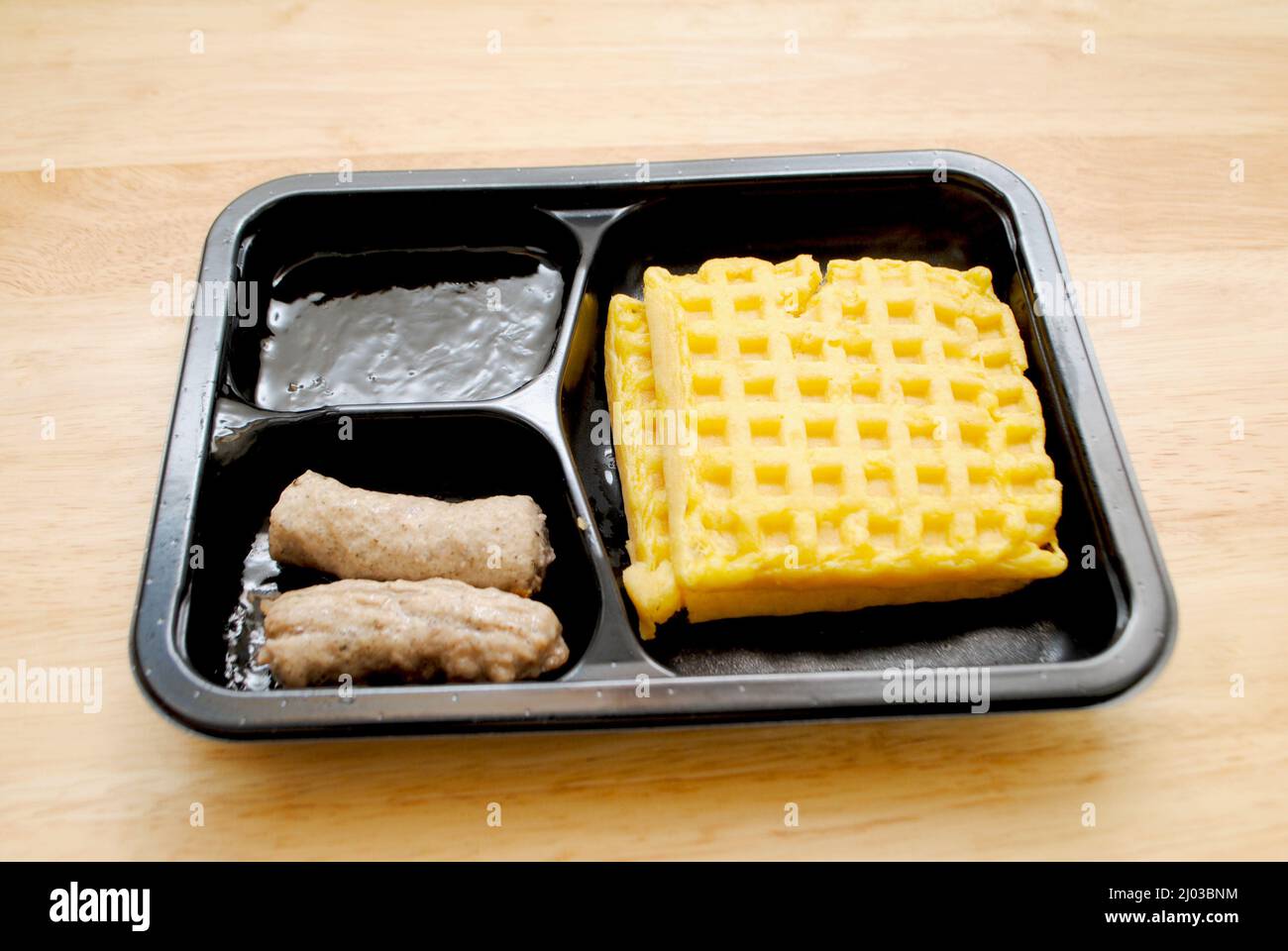 Petit-déjeuner au micro-ondes composé de pain grillé, de sirop d'érable et de saucisses Banque D'Images