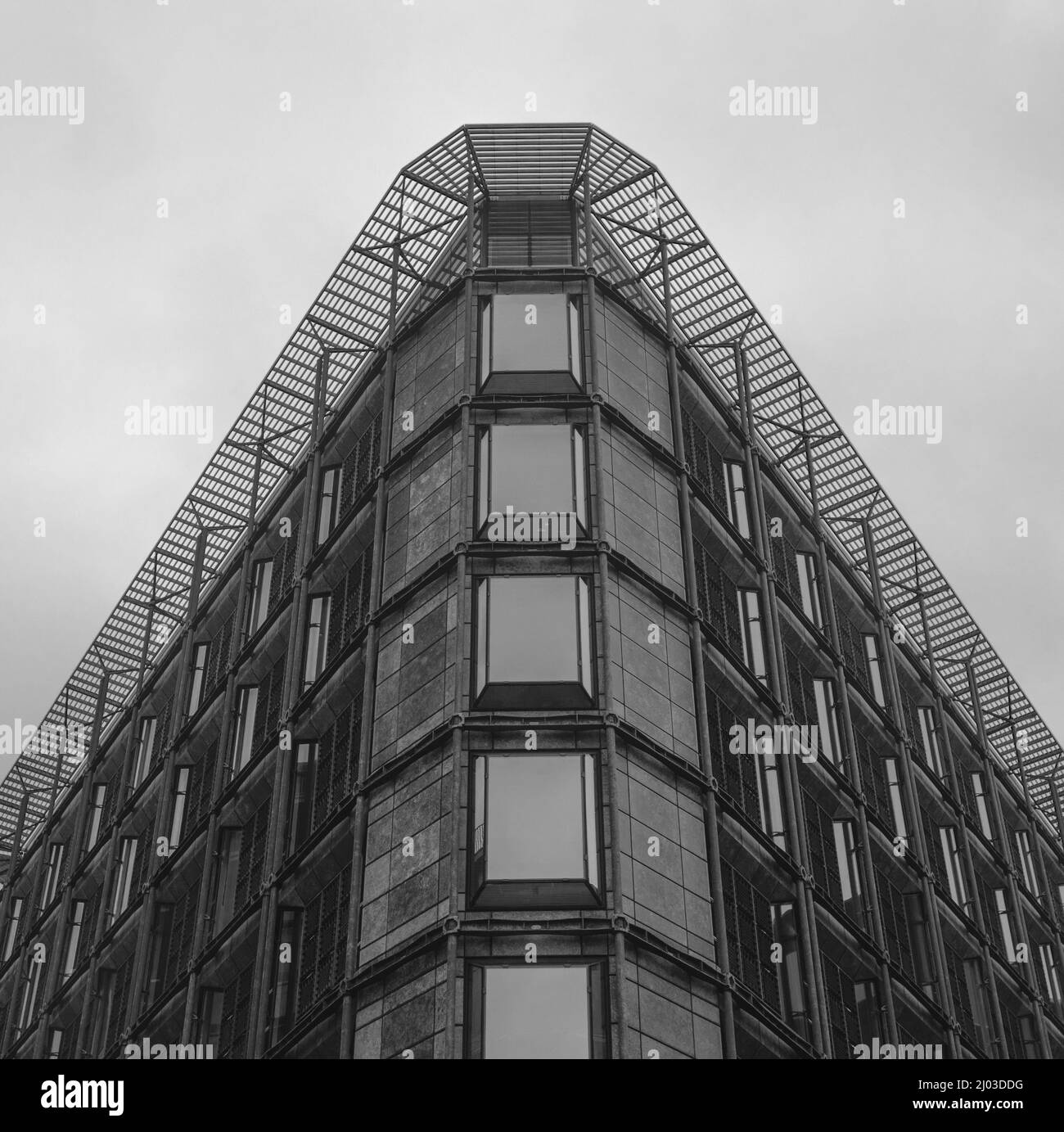 Bâtiment en forme de triangle à niveaux de gris avec de grandes fenêtres Banque D'Images