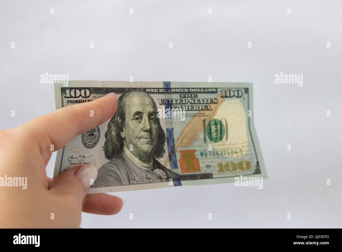 100 dollars en main gros plan sur un fond blanc isolé. Un billet de cent dollars Banque D'Images