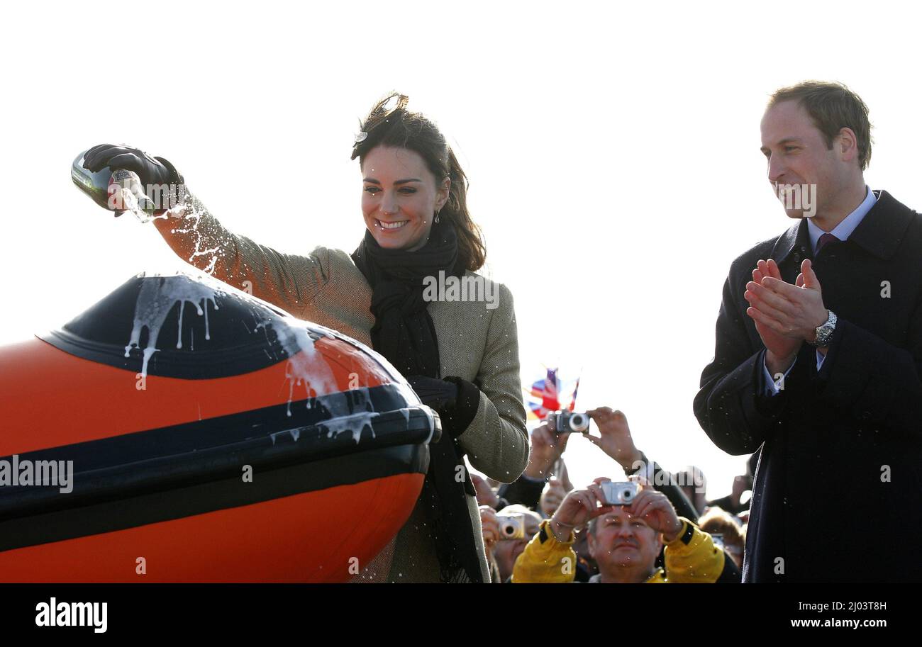 Photo du dossier datée du 24/02/2011, du Prince William regarde son fiancée Kate Middleton verser du champagne au-dessus de « Hereford Endeavour », lors d'une cérémonie de dénomination et d'un service de dédicace pour le nouveau canot de sauvetage Atlantic 85 de Royal National Lifeboat Instation (RNLI), à la station de Lifeboat de Trearddur Bay, à Trearddur Bay, à Trearddur Bay, Anglesey dans le nord du pays de Galles. Date de publication : le mercredi 16 mars 2022. Banque D'Images