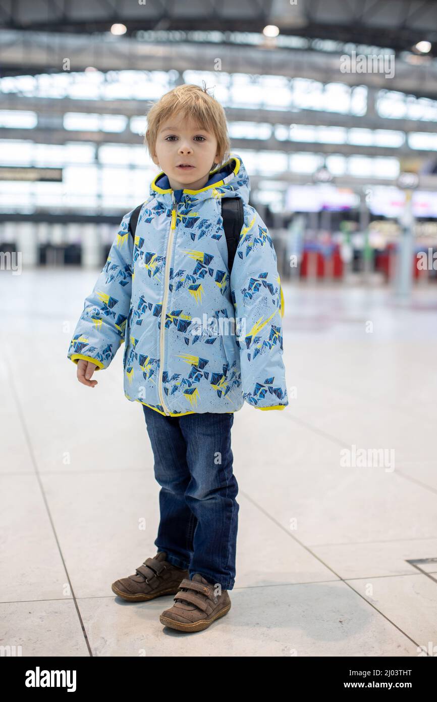 Un adorable bébé attendant d'embarquer pour un vol dans la salle de transit  de l'aéroport, près de la porte d'embarquement. Un mode de vie familial  actif voyage en avion avec un enfant