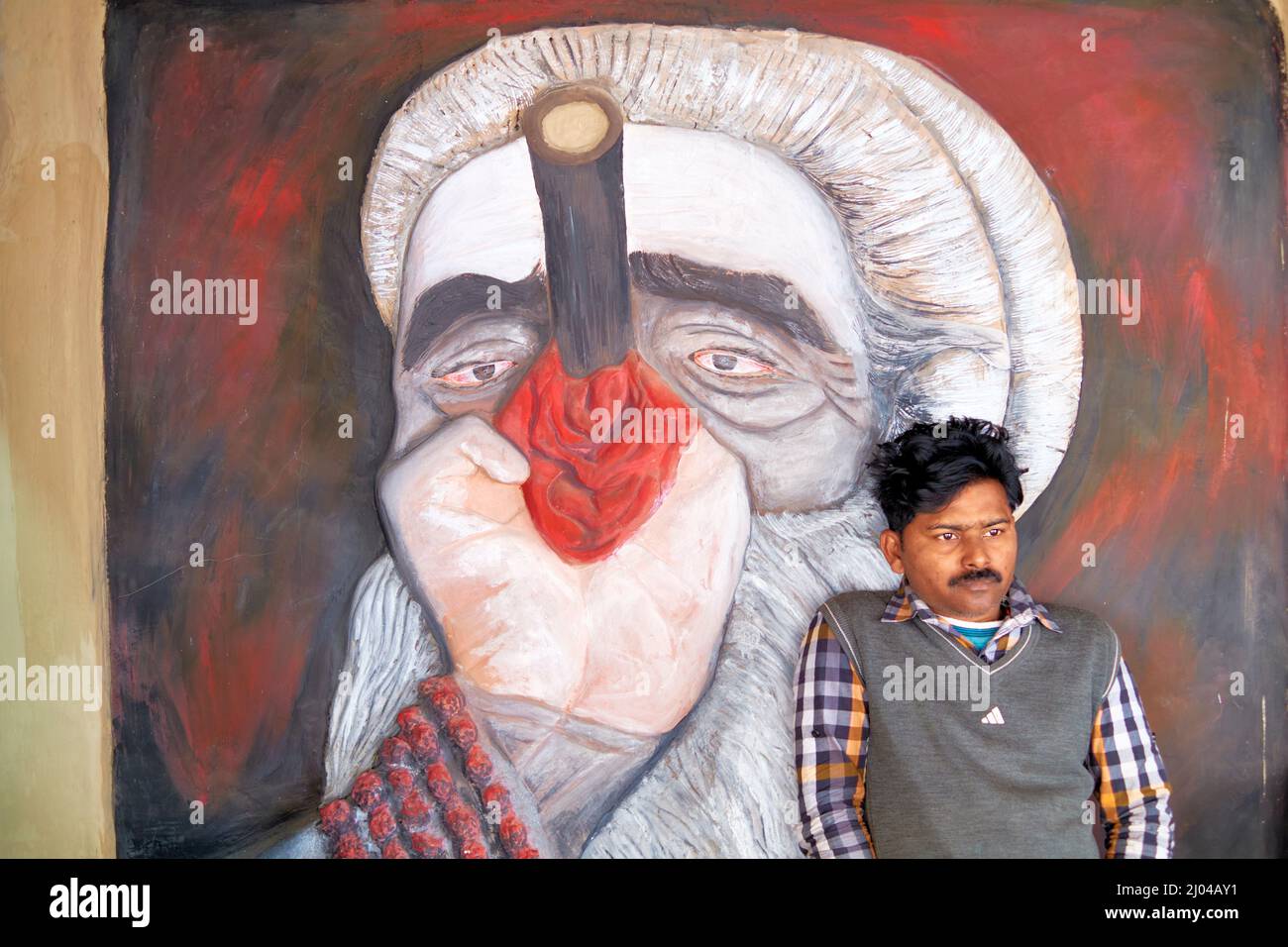 Inde. Varanasi Benares Uttar Pradesh. Peinture d'homme et de rue représentant un chilum haschisch Banque D'Images