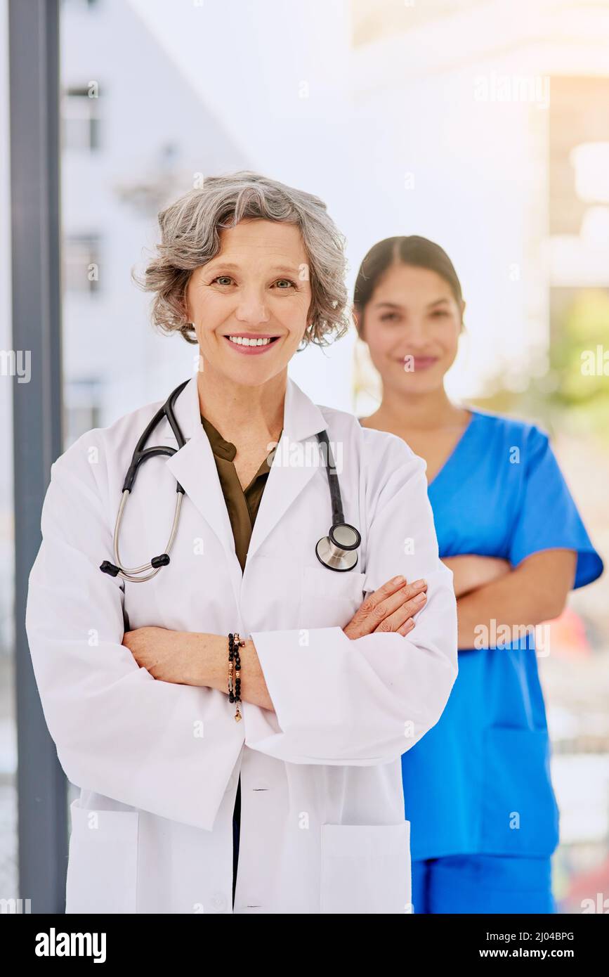 Shes mon nouveau stagiaire. Portrait d'une femme médecin debout devant son inter avec les deux bras repliés. Banque D'Images