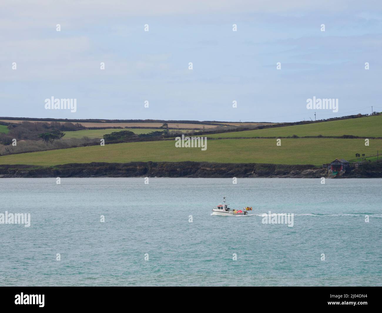 Petit bateau de pêche se dirigeant vers le port de Padstow le long de l'estuaire de la Camel, Cornwall, Royaume-Uni Banque D'Images