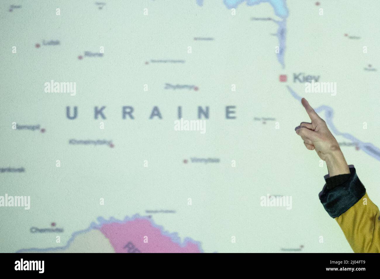 Gros plan de la main de la femme pointant vers Kiev, la capitale de l'Ukraine, sur une carte de l'Europe de l'est Banque D'Images