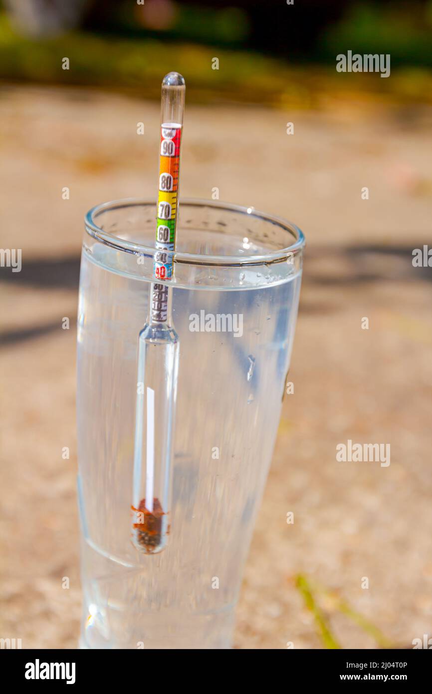 Un échantillon d'alcool fraîchement distillé, alcool dans le cylindre gradué de laboratoire. Banque D'Images