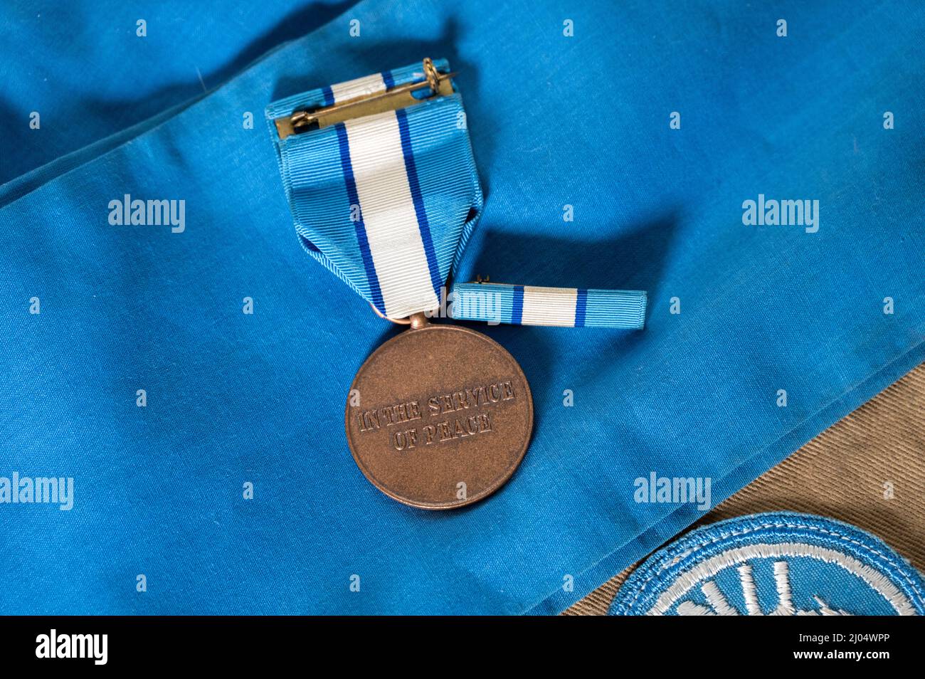Photo aérienne du dos d'une médaille et d'un ruban de service du gardien de la paix des Nations Unies sur un cravat bleu de l'ONU Banque D'Images