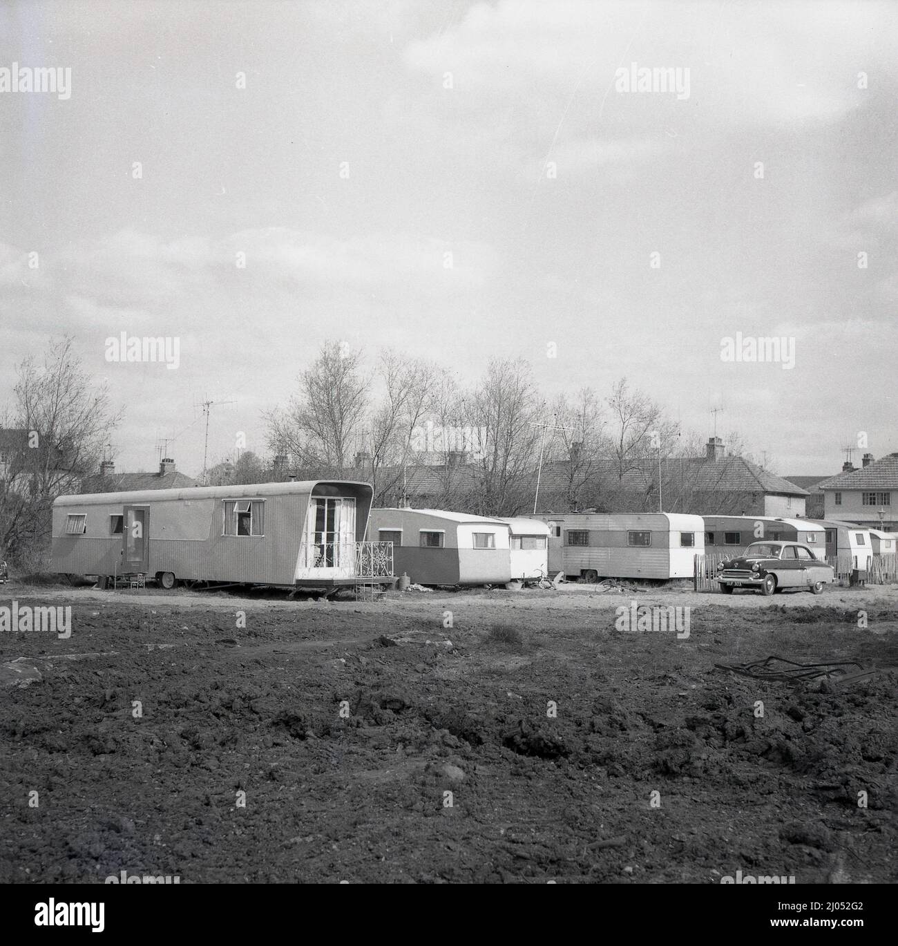 1960s, historique, sur un terrain de derlict derrière une maison, une longue caravane à roues - la plus longue en Angleterre ? - Garés en étant utilisés comme maison mobile, Oxford, Angleterre, Royaume-Uni. Banque D'Images