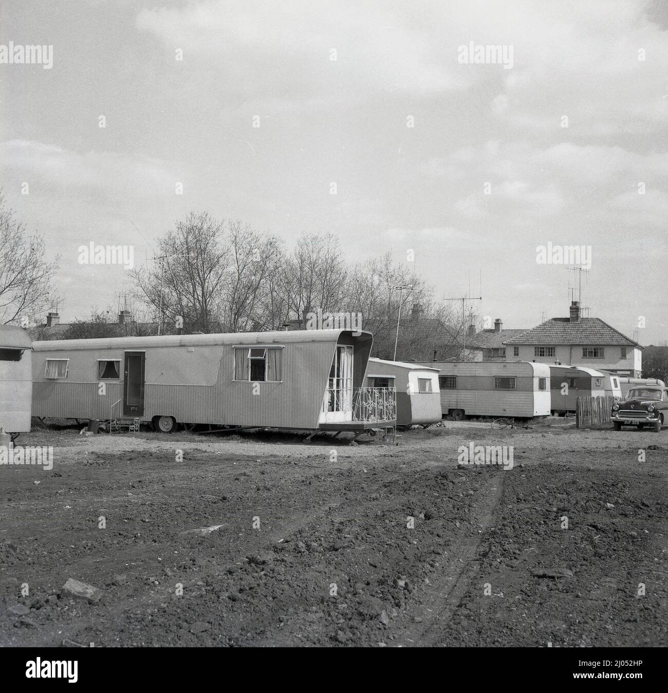 1960s, historique, sur un terrain de derlict derrière une maison, une longue caravane à roues - la plus longue en Angleterre ? - Garés en étant utilisés comme maison mobile, Oxford, Angleterre, Royaume-Uni. Banque D'Images