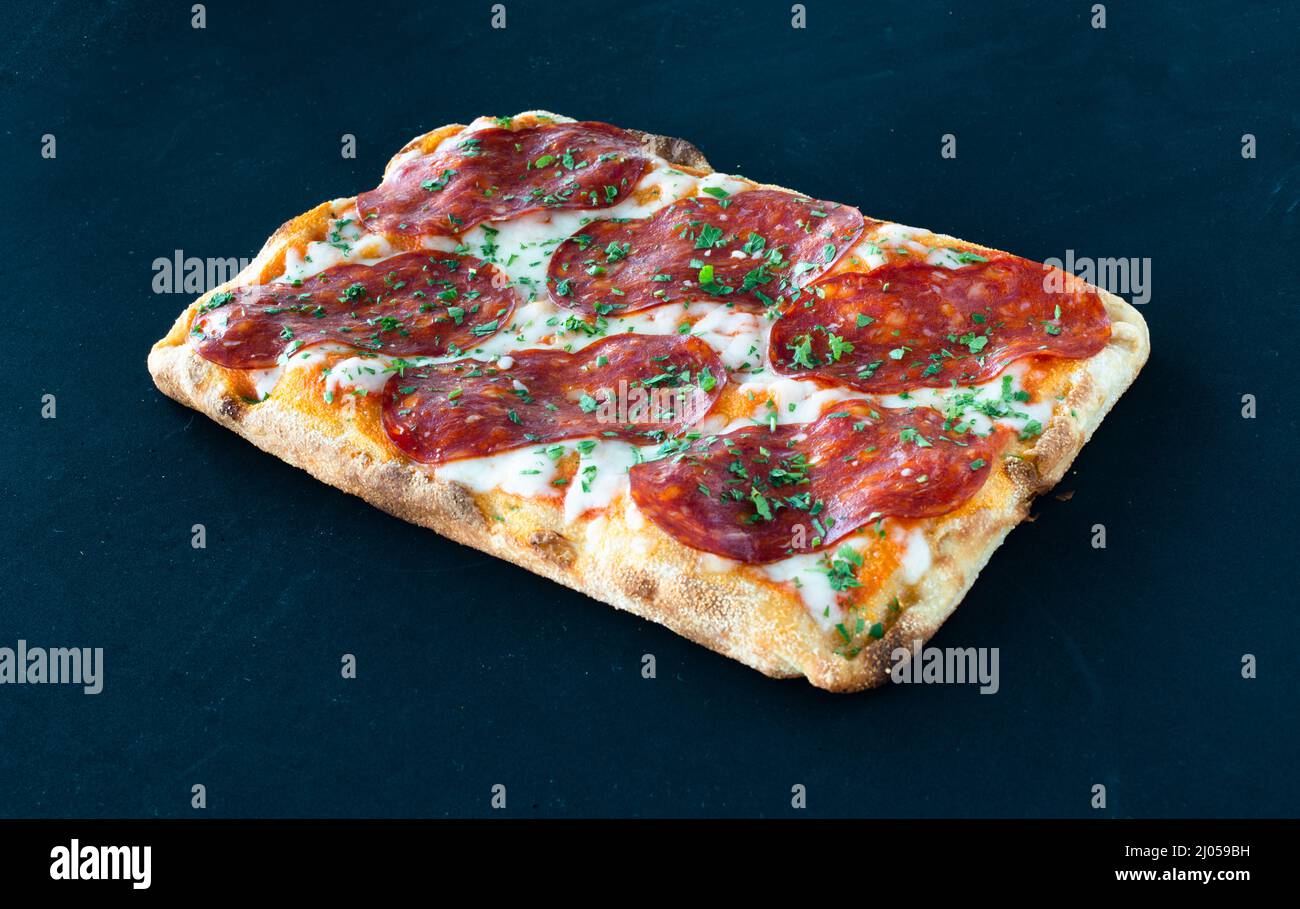 Salami pizza al taglio isolé sur BGD noir Banque D'Images